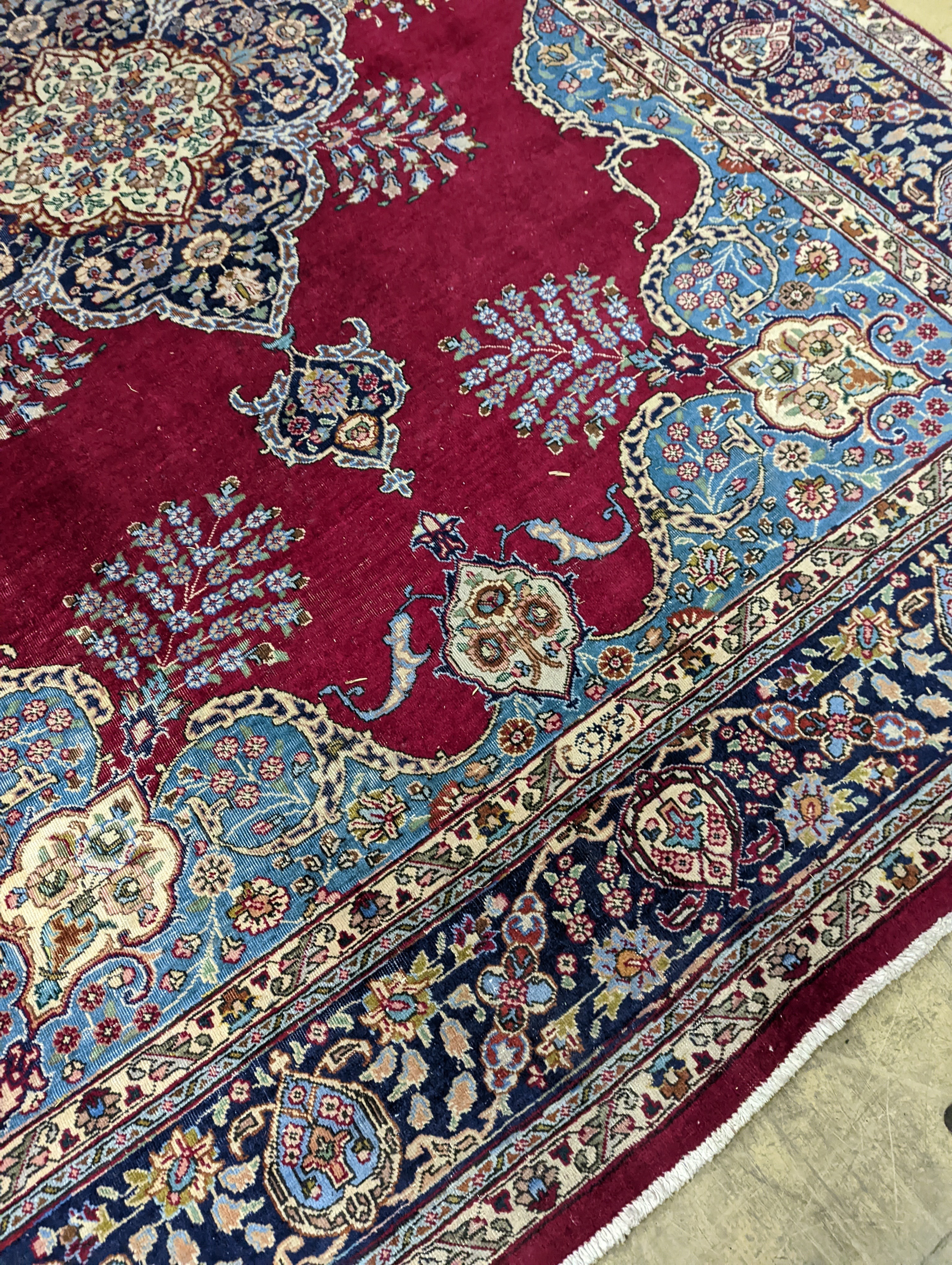 A Tabriz burgundy ground carpet, 350 x 240cm